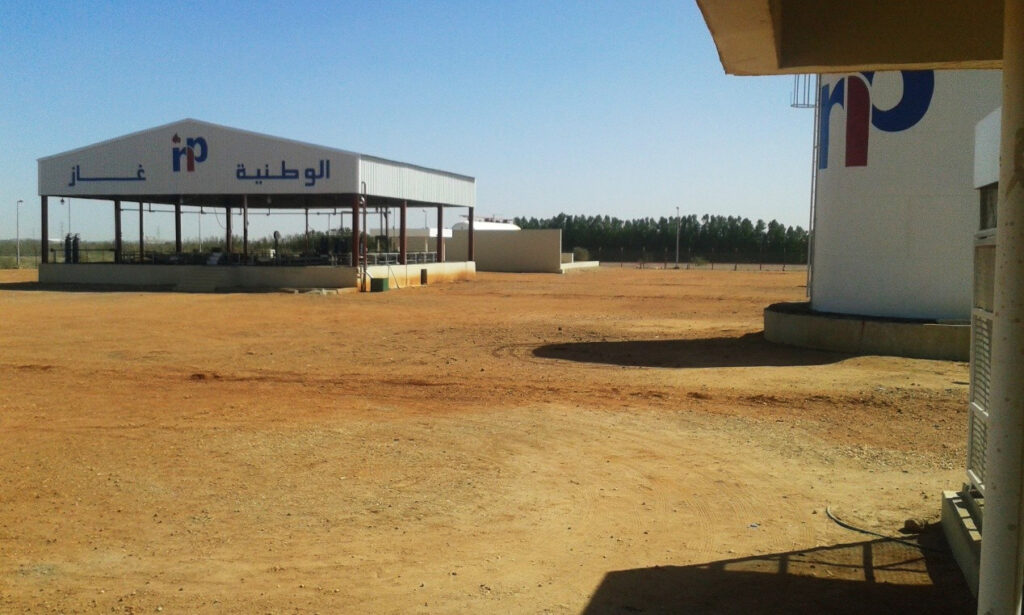 A wide view of the warehouse's operations area combines a vertical strategic storage tank with a gas cylinder filling unit, highlighting the engineering layout of the facility.