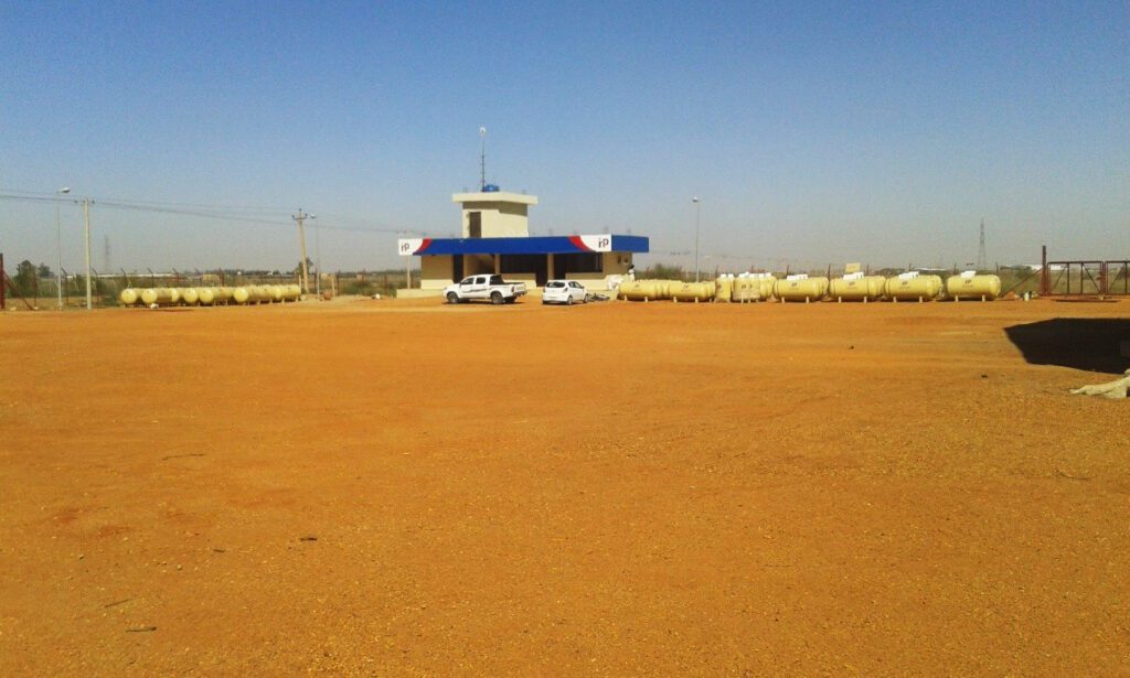 The administrative building and warehouse control centre, surrounded by a fleet of horizontal gas transport tanks designed for regional distribution, with a spacious parking and unloading yard.