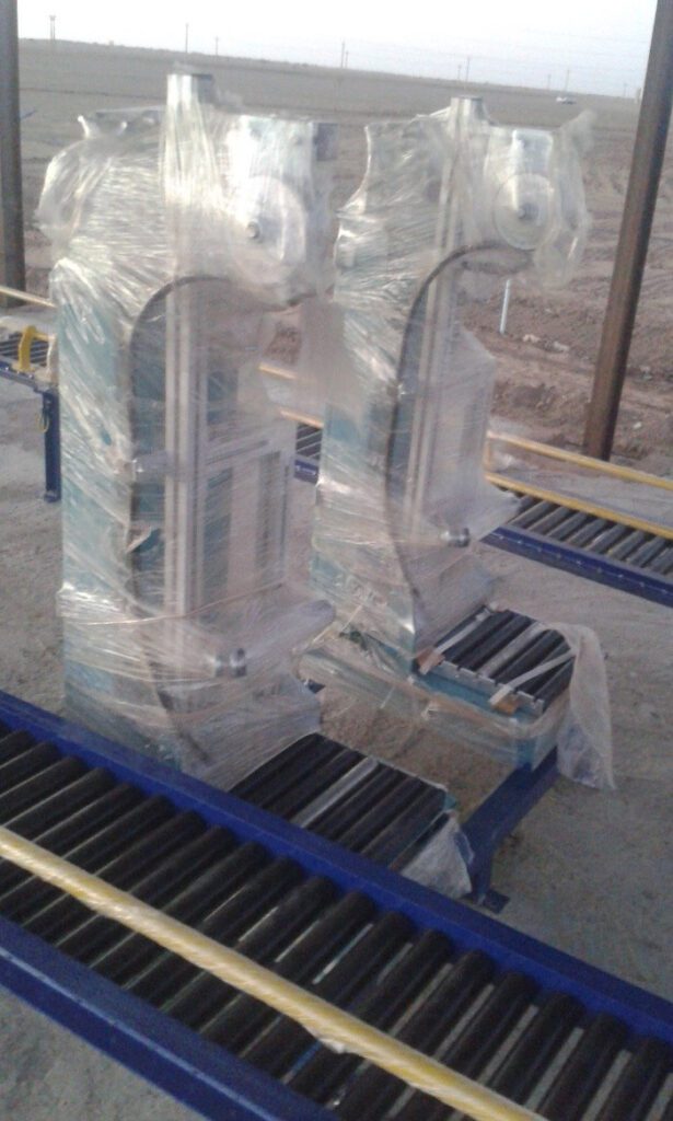 A close-up shot of the advanced automated packaging units, encased to protect them during delivery, and installed on logistical conveyor belts (Conveyor Belts) to increase the efficiency of cylinder handling.