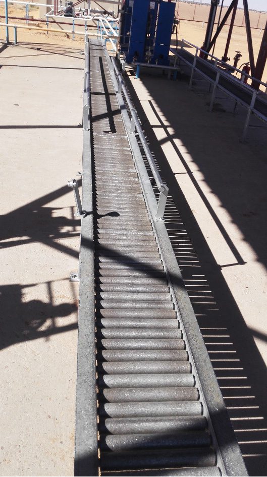 Roller Conveyors system in Al Multaqa warehouse, designed to move gas cylinders with high efficiency between filling units and loading platforms, with gas pipes and safety systems in the background.