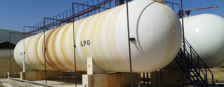 Huge horizontal tanks for storing liquefied petroleum gas (LPG), mounted on sturdy concrete foundations with clearly marked markings, with iron platforms visible above for safe access to relief and metering valves.