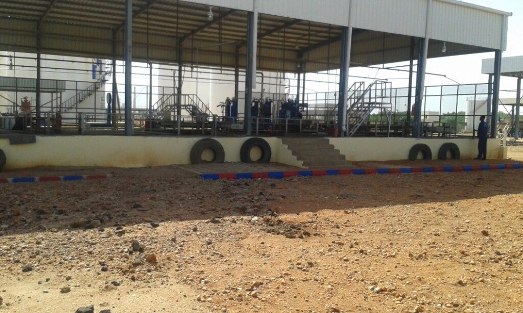 Exterior view of a gas cylinder filling platform, featuring an open-sided structural design to ensure natural ventilation and prevent gas accumulation, equipped with protective barriers and rubber bumpers to secure handling operations.