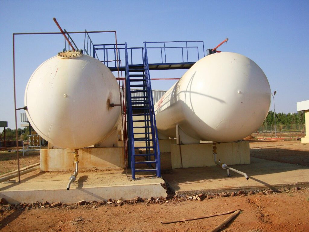 A general view of the petroleum products storage depot showing the construction canopies for the pumping and transfer stations, next to the field of vertical tanks within an organized operational environment that follows safety protocols.