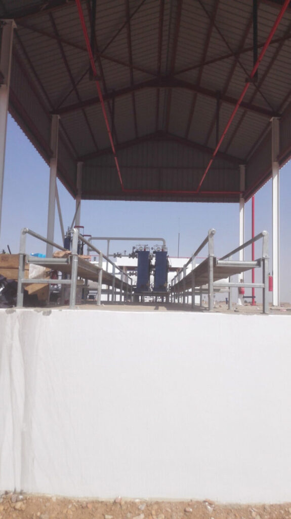 A shot from inside the packing platform in the Dongola warehouse under the protective metal canopy, showing the tracks designated for organizing the movement of cylinders and the overhead fire-fighting systems.