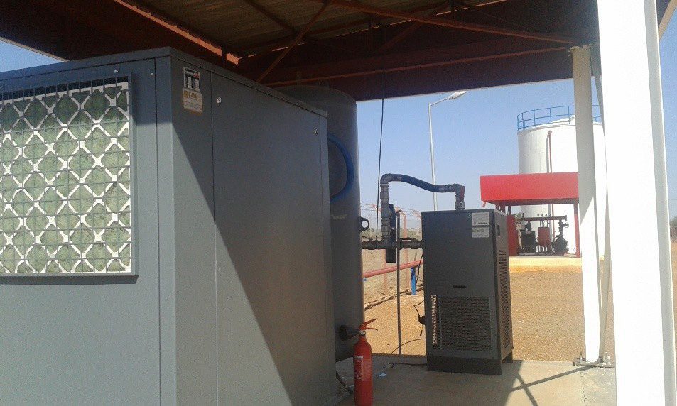 An industrial air compressor unit designed for heavy-duty operations inside the warehouse. It supplies control systems and pneumatic equipment with the necessary energy, next to a capacity tank and an air drying system.