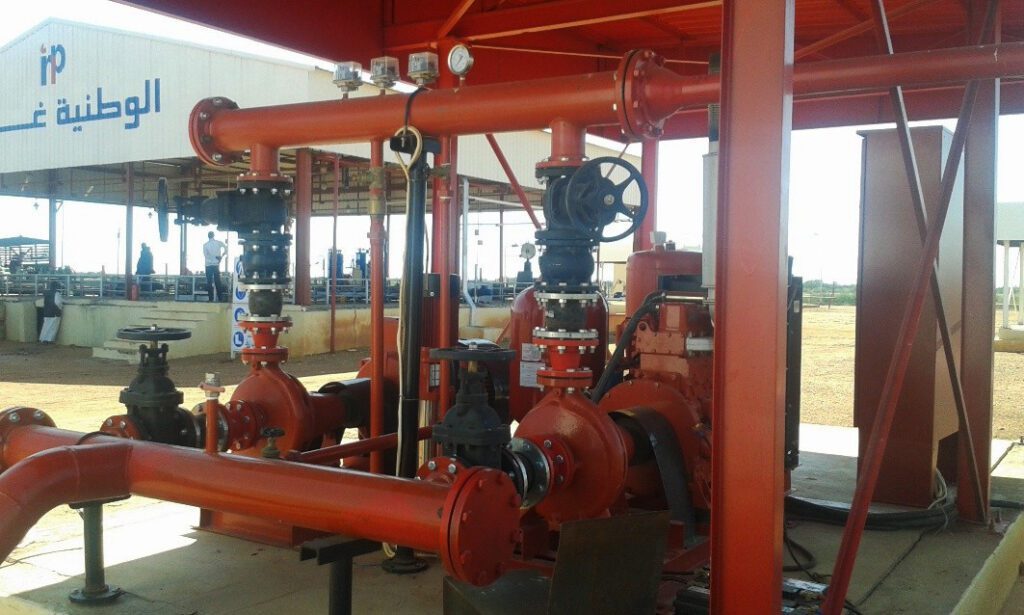 An integrated centrifugal pump system, painted in the red color designated for fire-fighting systems, is equipped with manual isolation valves and leak-proof plugs to ensure efficient pumping of liquids in emergency situations.
