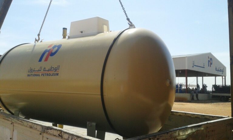 خزان غاز مسال (LPG) يتم نقله بواسطة شاحنة مخصصة، مع ظهور مرافق المستودعات في الخلفية، مما يبرز حلقة الوصل اللوجستية في سلسلة إمداد الطاقة وضمان وصول المنتجات للمستهلكين.
