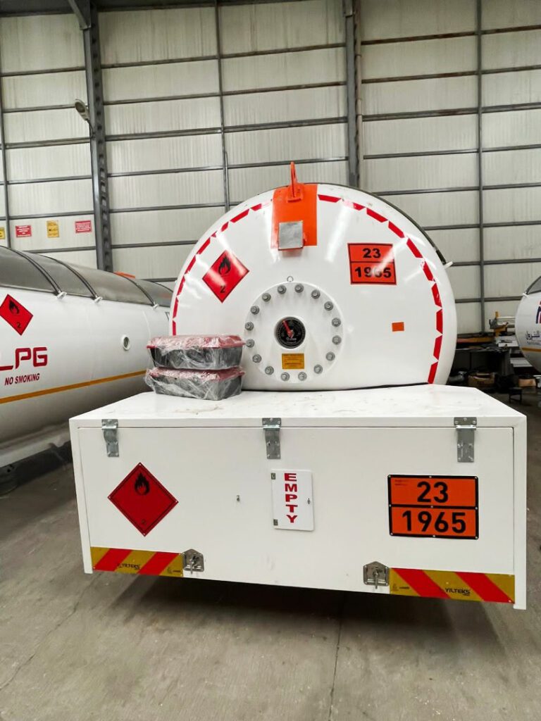 The back of the LPG Tanker shows global warning labels, pressure indicators, and safety valves, confirming strict adherence to international safety standards in transporting hazardous materials.